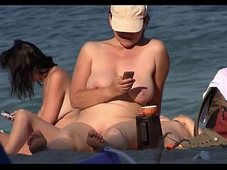 Chicas nudistas desvergonzadas tomando el sol en la playa en la cámara espía
